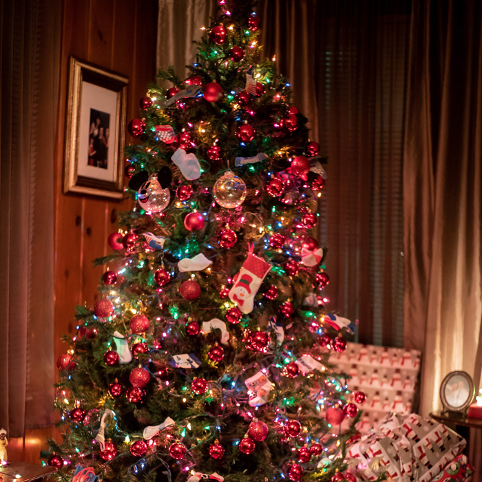 Christmas tree decorated with colorful lights and red baubles, surrounded by wrapped presents for festive celebrations. Christmas tree decorated with colorful lights and red baubles, surrounded by wrapped presents for festive celebrations.