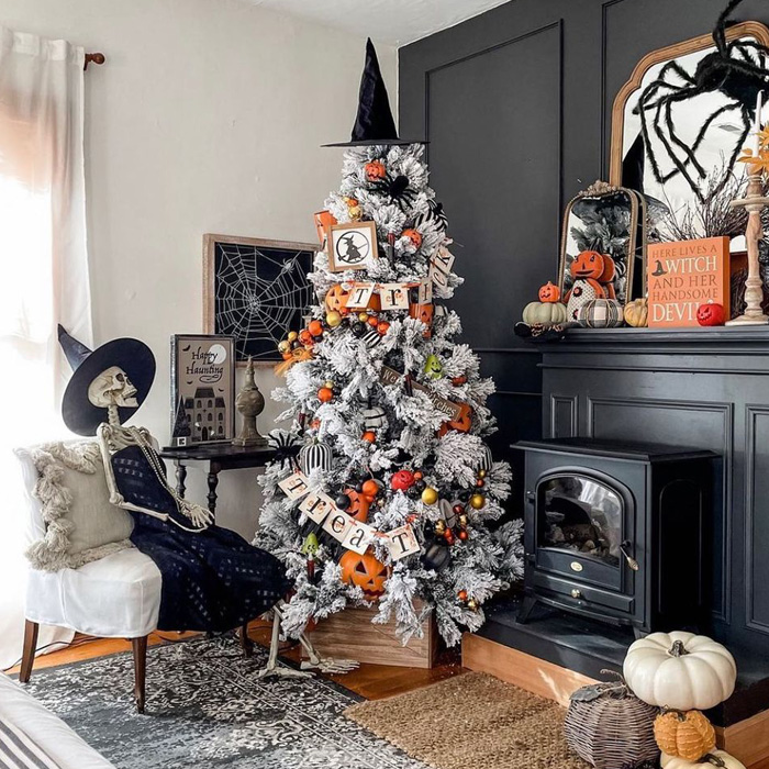 Halloween decorated Christmas tree next to a skeleton and fire place 