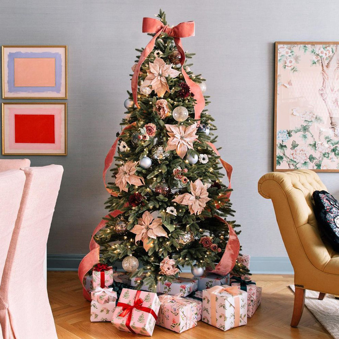 Pale pink Christmas tree with presents under it 