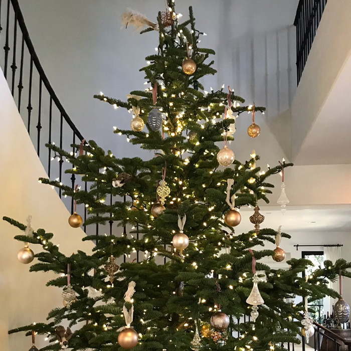 Decorated Christmas tree next to a staircase 