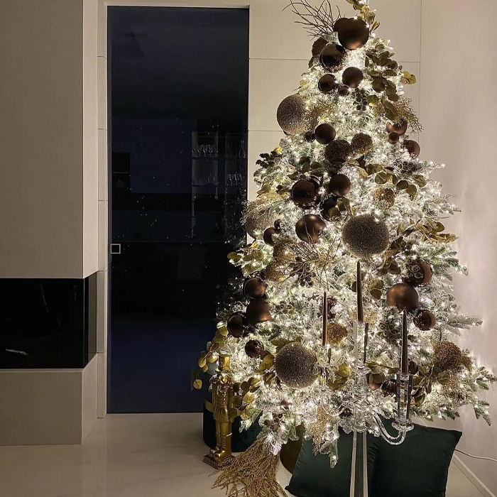 Decorated Christmas tree with green cushions under it 