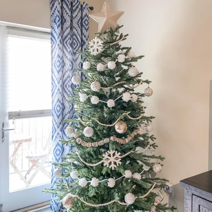 Decorated Christmas tree with a star at the top in the corner of a room 