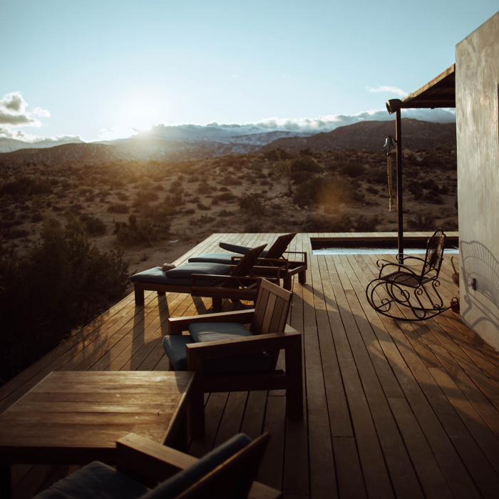 Brown wooden chairs on the deck with a sunset view 