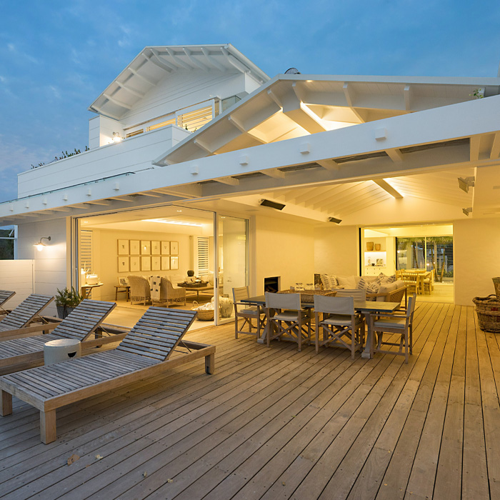 White wooden covered deck with outdoor furniture 