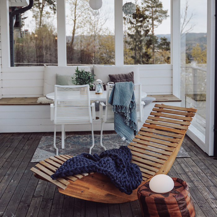 Wooden armchair with cozy blanket on a creative backyard deck enhancing your time outdoors with stylish comfort. Wooden armchair with cozy blanket on a creative backyard deck enhancing your time outdoors with stylish comfort.