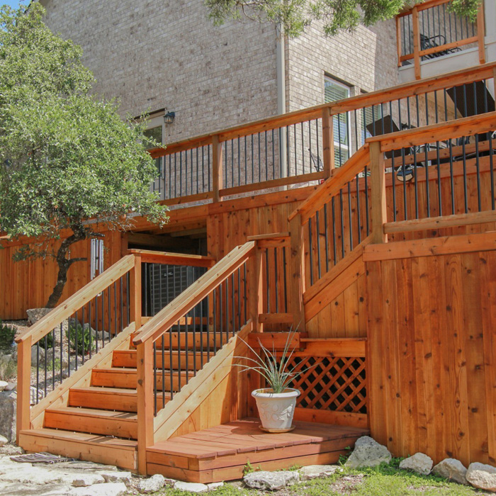 Natural wood backyard deck with stairs and railing surrounded by greenery, showcasing creative backyard deck ideas outdoors. Natural wood backyard deck with stairs and railing surrounded by greenery, showcasing creative backyard deck ideas outdoors.