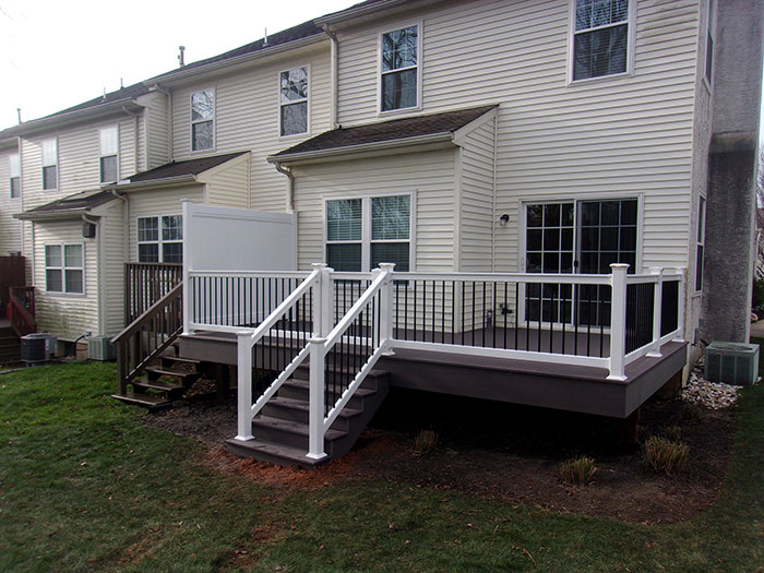 White and black deck railing design with stairs near a house, showcasing modern deck railing ideas for exterior spaces. White and black deck railing design with stairs near a house, showcasing modern deck railing ideas for exterior spaces.
