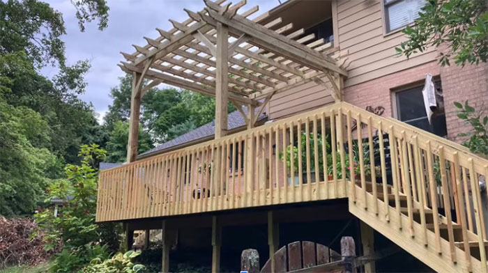 Wooden deck railing with pergola design enhancing outdoor space and adding style to exterior deck area Wooden deck railing with pergola design enhancing outdoor space and adding style to exterior deck area