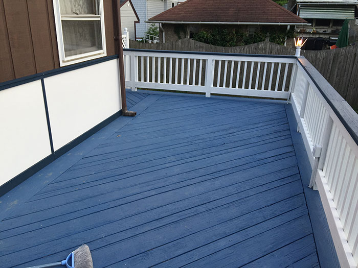 Black and white deck railing design on a blue porch deck, showcasing modern deck railing ideas and exterior style. Black and white deck railing design on a blue porch deck, showcasing modern deck railing ideas and exterior style.