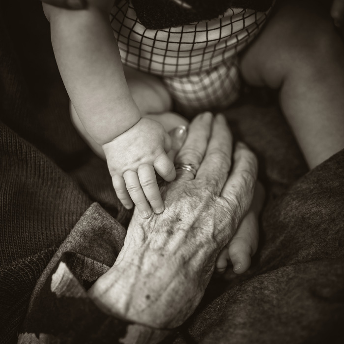 An older woman's hand and a hand of a baby 