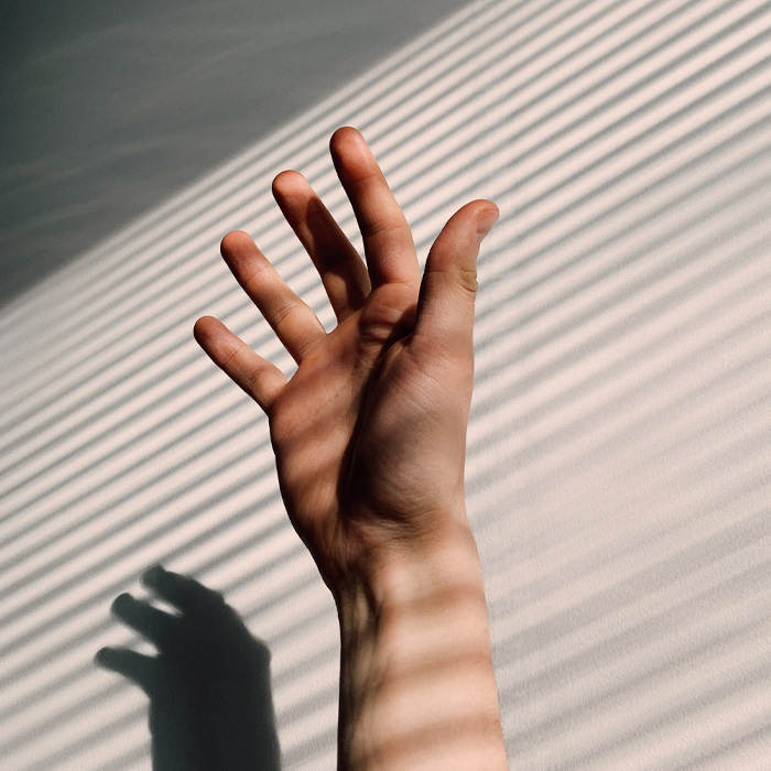 A hand with a shadow from window blinds