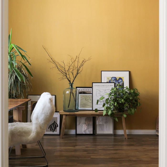 Yellow room with white chair and plants 