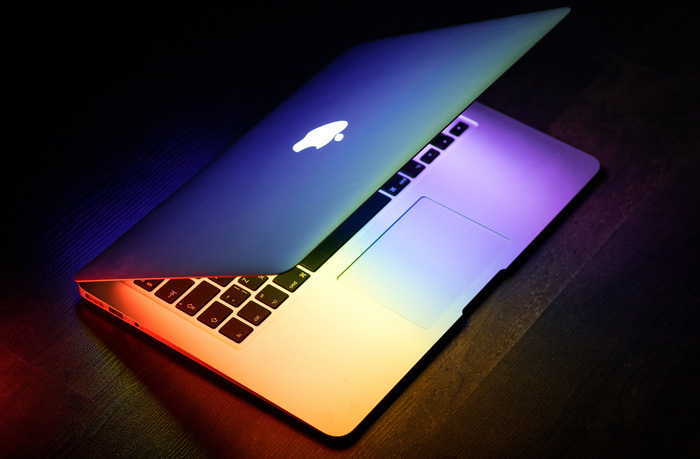 A MacBook lit up in rainbow 