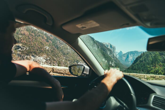 man driving a car and looking at mountains