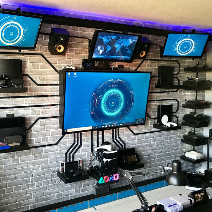 Game room ideas featuring multiple mounted game consoles and screens arranged on a wall for a gaming setup. Game room ideas featuring multiple mounted game consoles and screens arranged on a wall for a gaming setup.