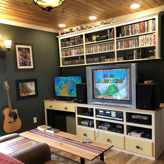 Game room featuring retro gaming consoles, a Super Mario World display, and patterned decor for a cozy gaming cave. Game room featuring retro gaming consoles, a Super Mario World display, and patterned decor for a cozy gaming cave.