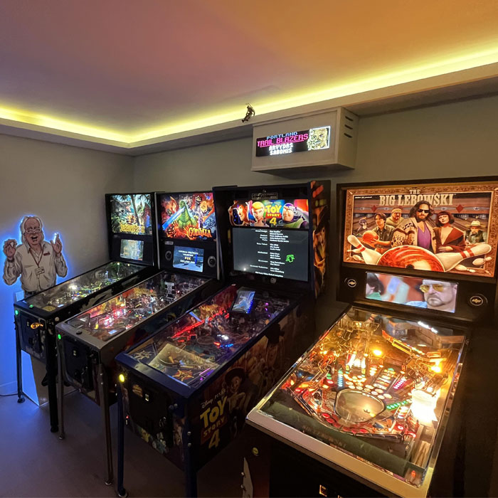 Pinball machine lit up in a game room corner featuring bright lights and colorful artwork for game room ideas. Pinball machine lit up in a game room corner featuring bright lights and colorful artwork for game room ideas.