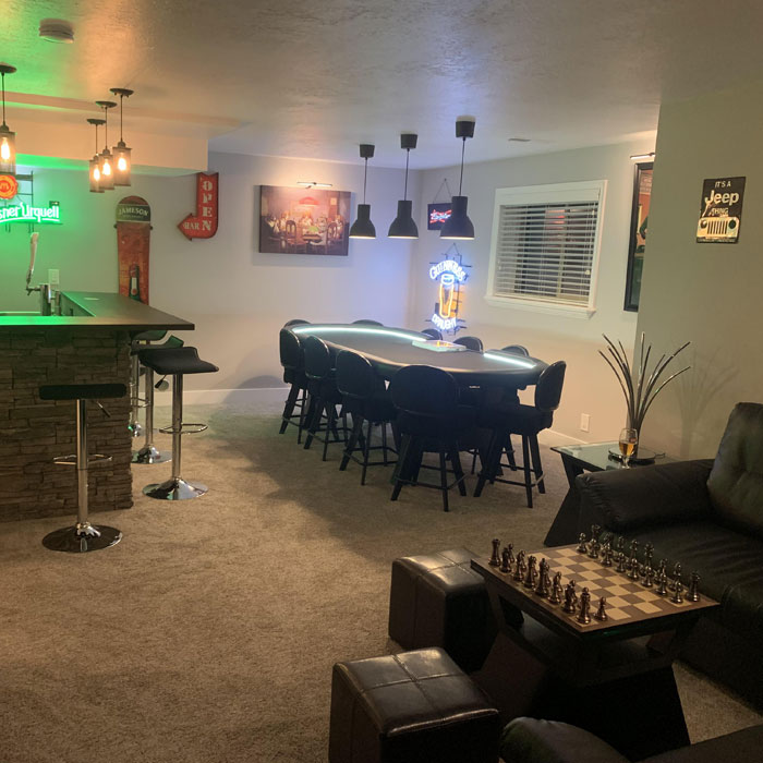 Spacious game room featuring a poker table, bar area, and cozy seating showcasing game room ideas for gaming caves. Spacious game room featuring a poker table, bar area, and cozy seating showcasing game room ideas for gaming caves.