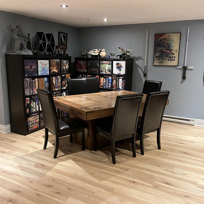 Spacious game room with a large wooden table for board games and shelves filled with game collections and models. Spacious game room with a large wooden table for board games and shelves filled with game collections and models.