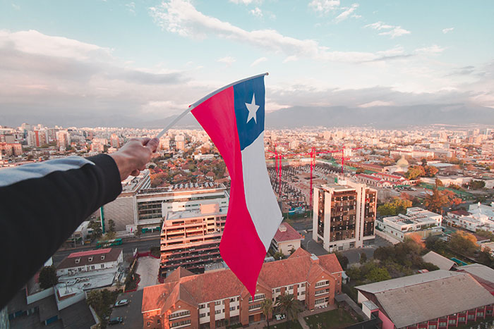 Man holding Chilean flag above the city