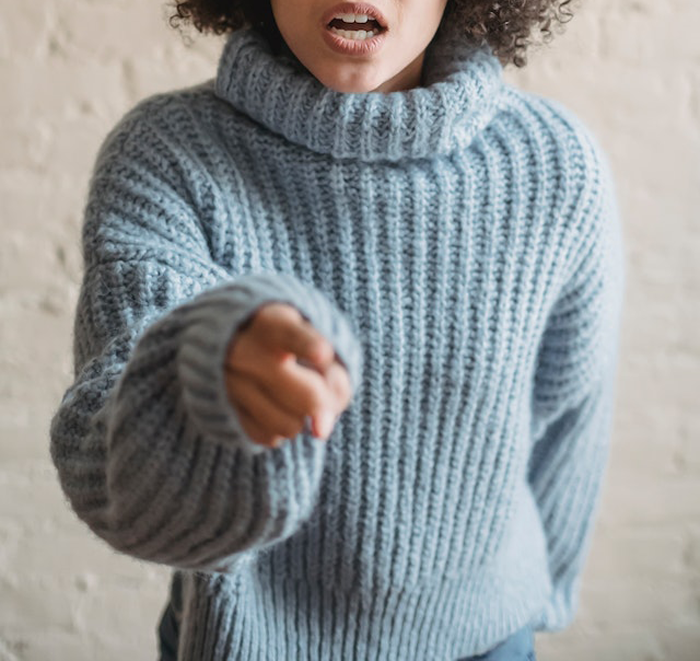 Teen girl in blue sweater pointing and shaming older sister for getting pregnant multiple times indoors. Teen girl in blue sweater pointing and shaming older sister for getting pregnant multiple times indoors.