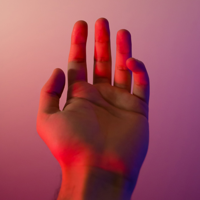 Human hand under pink light 