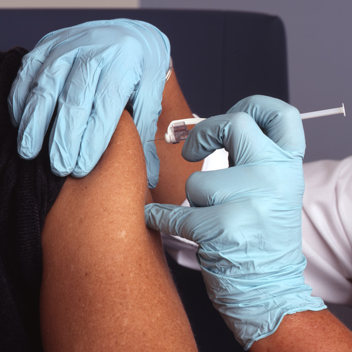 Person i. white gloves vaccinates another person 