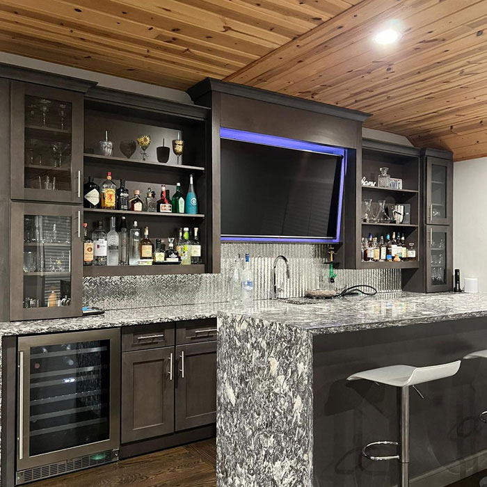 Marbled home bar with island and bar stools 
