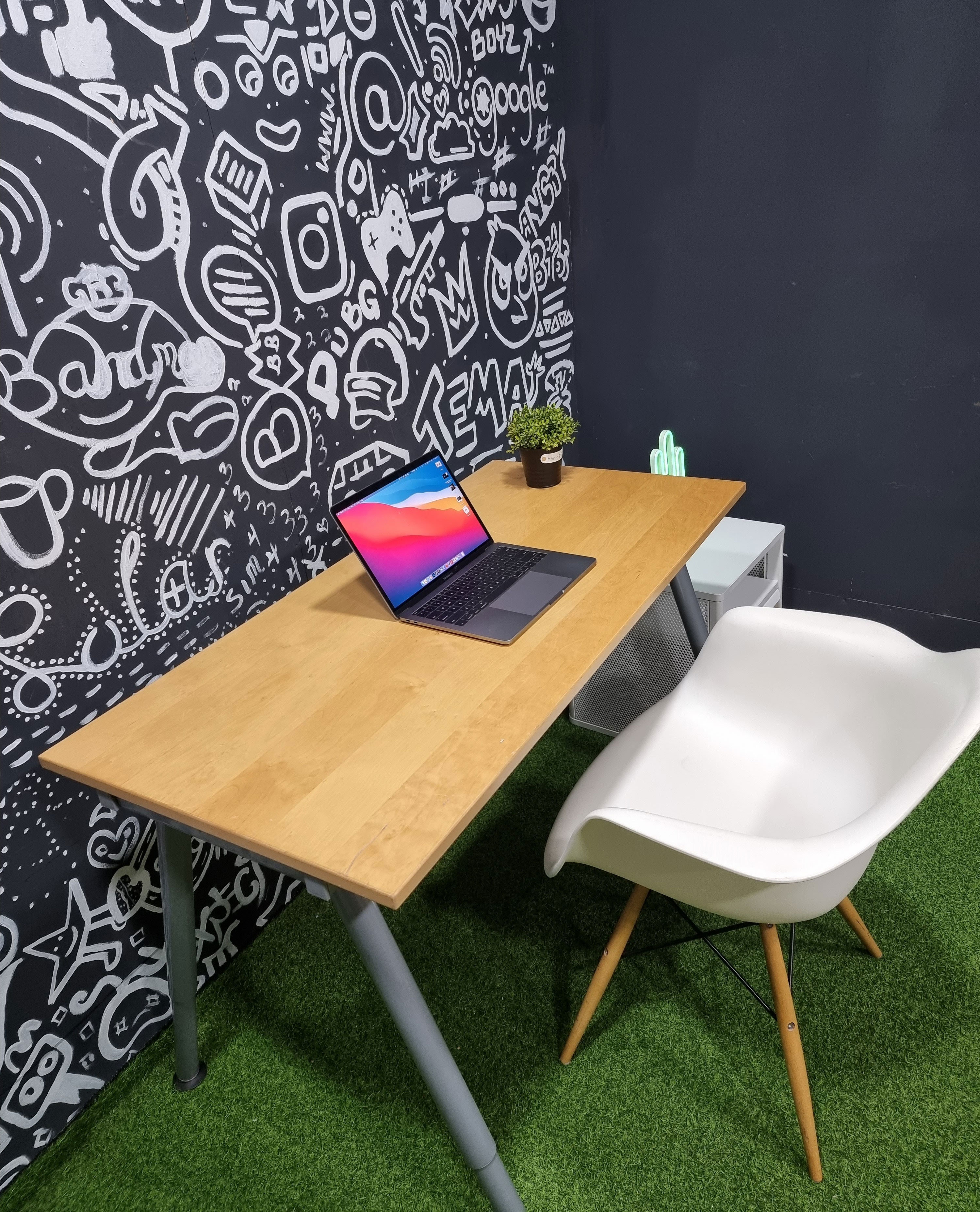 Minimalist home office setup with laptop on wooden desk, white chair, and creative wall art for inspired workspaces. Minimalist home office setup with laptop on wooden desk, white chair, and creative wall art for inspired workspaces.