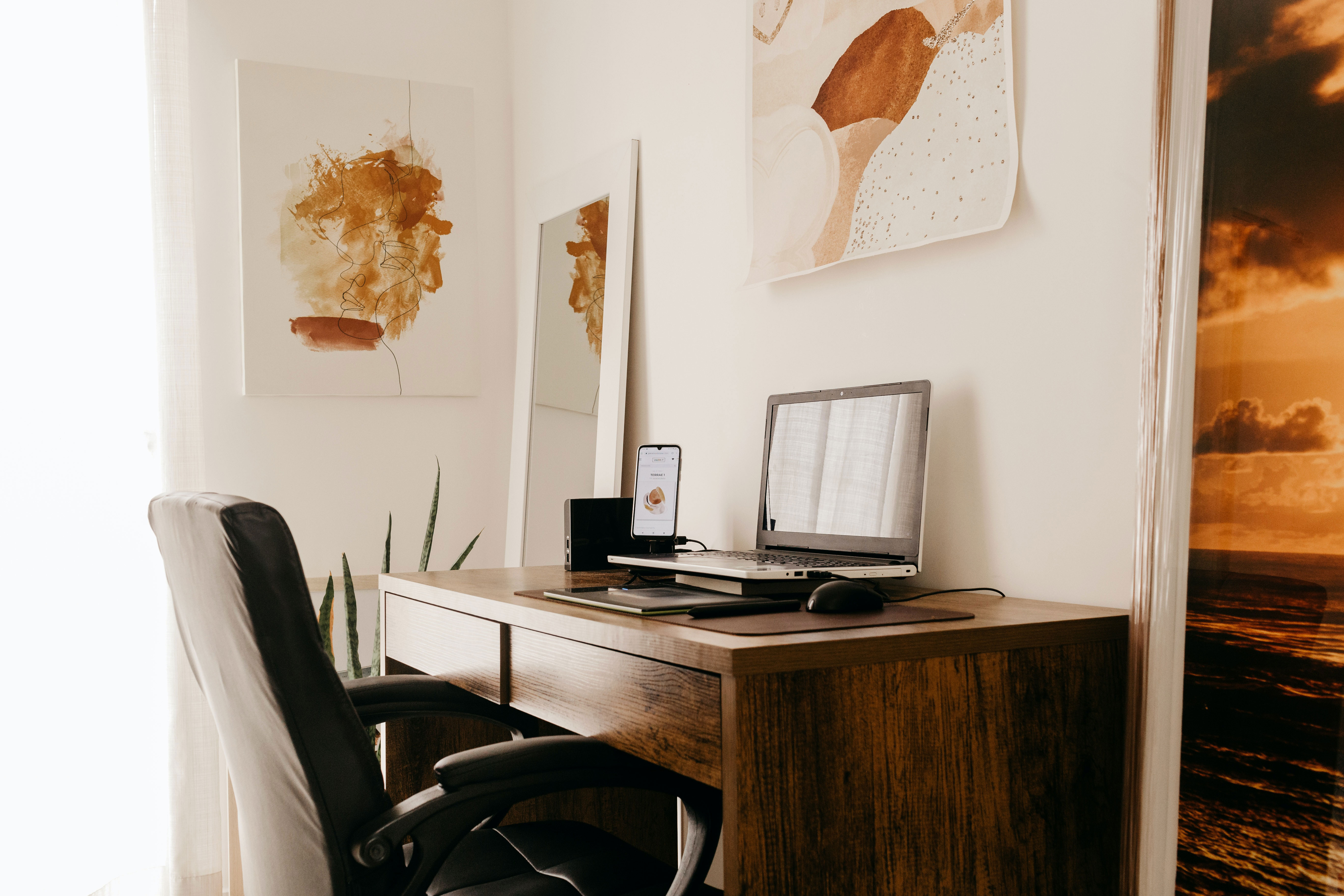 Black laptop on a brown wooden desk in a home office setup for inspired and productive work process. Black laptop on a brown wooden desk in a home office setup for inspired and productive work process.