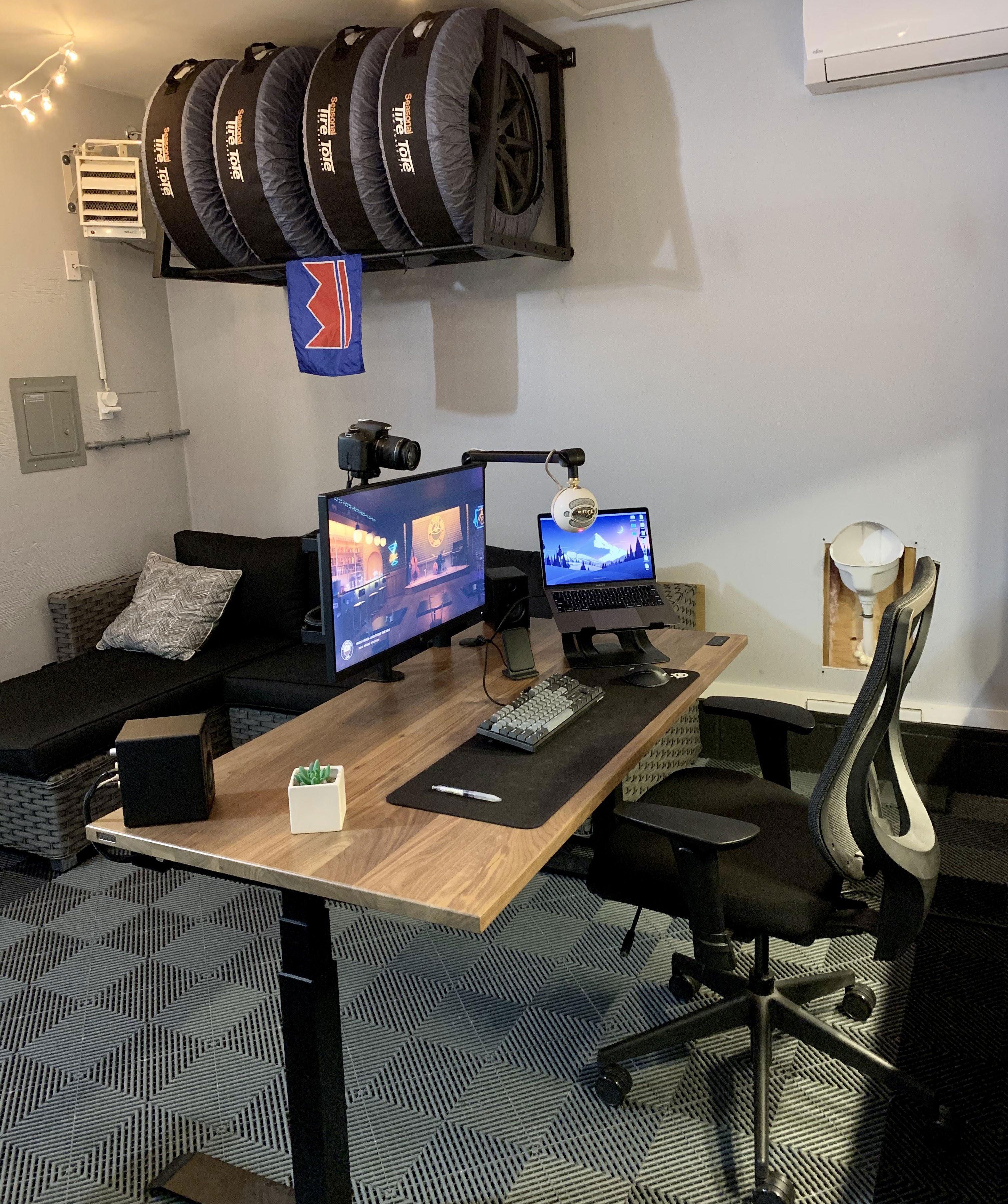 Modern home office setup with monitor, laptop on wooden desk, ergonomic office chair, and cozy seating area. Modern home office setup with monitor, laptop on wooden desk, ergonomic office chair, and cozy seating area.