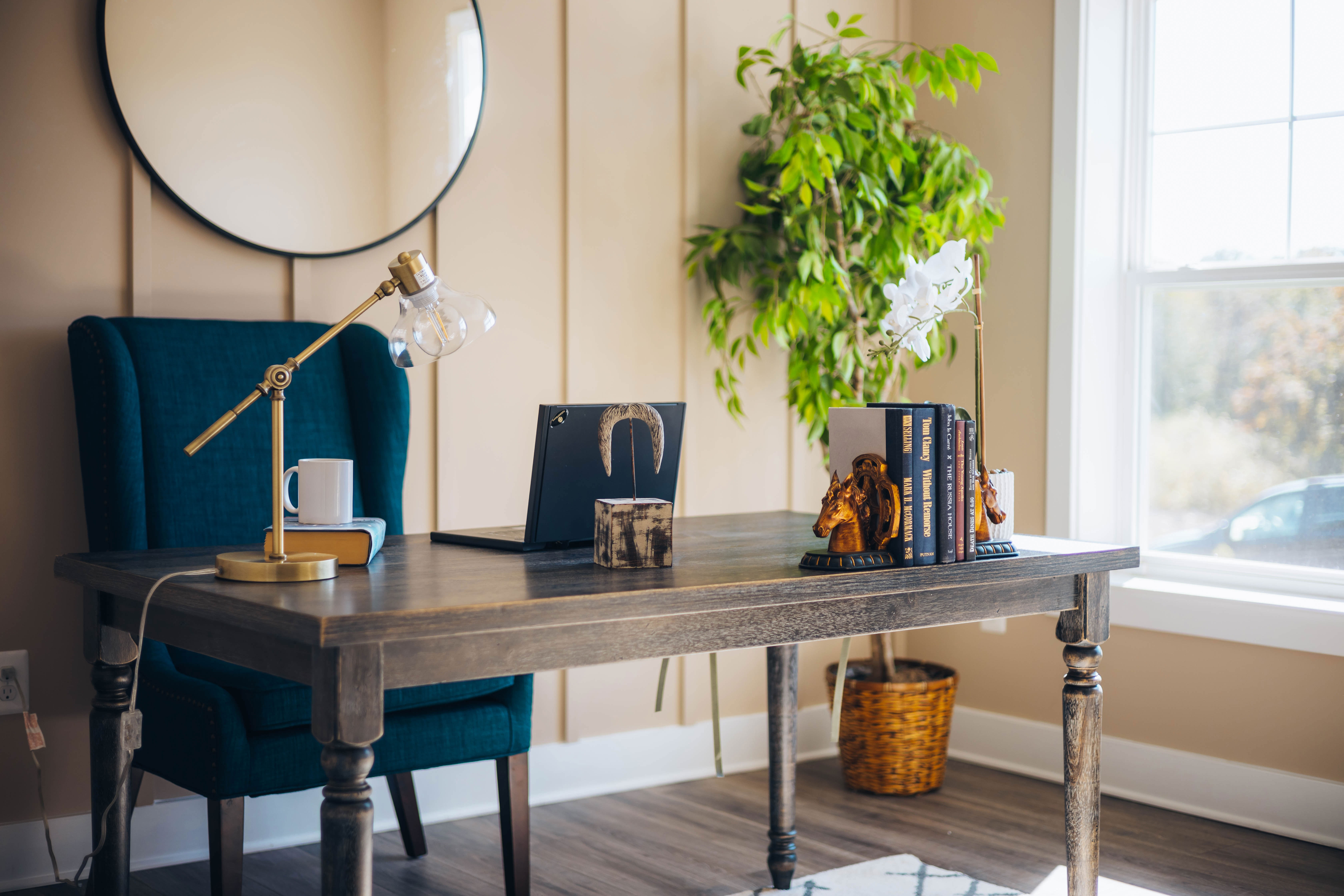 Laptop on brown wooden desk with decorative books and a lamp in a cozy home office setup for productivity. Laptop on brown wooden desk with decorative books and a lamp in a cozy home office setup for productivity.