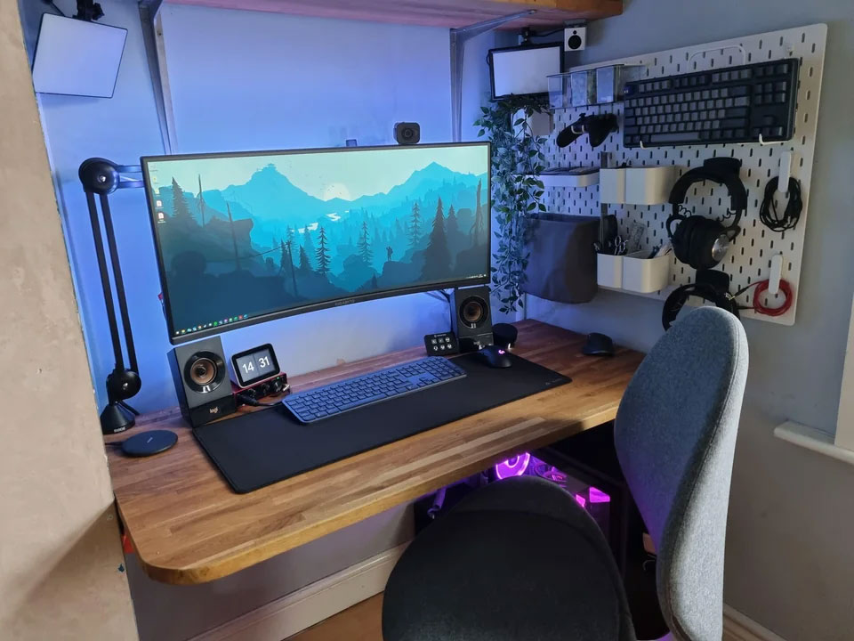 Modern home office setup with big monitor on wooden desk, featuring organized accessories for inspired and productive work. Modern home office setup with big monitor on wooden desk, featuring organized accessories for inspired and productive work.