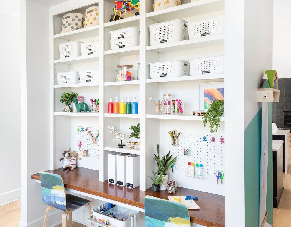 Wooden desk with white bookshelf and colorful chairs