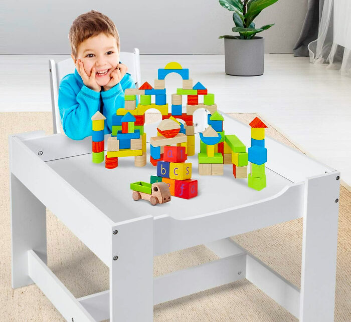 Kid sitting at a white desk with wooden castle