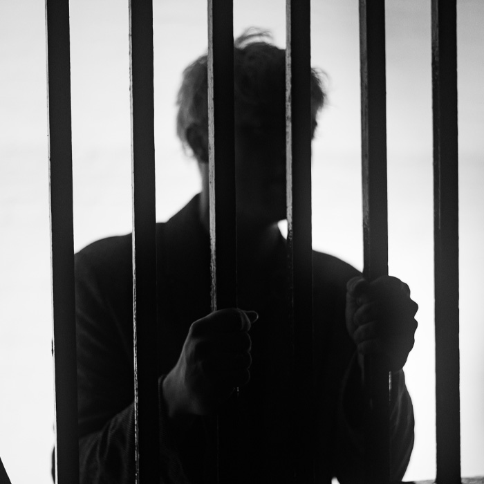 A man standing behind the bars 