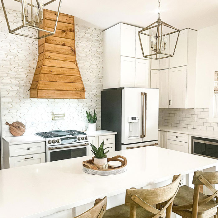 Bright white kitchen featuring a wooden range hood stained in Minwax Golden Oak wood stain color. Bright white kitchen featuring a wooden range hood stained in Minwax Golden Oak wood stain color.