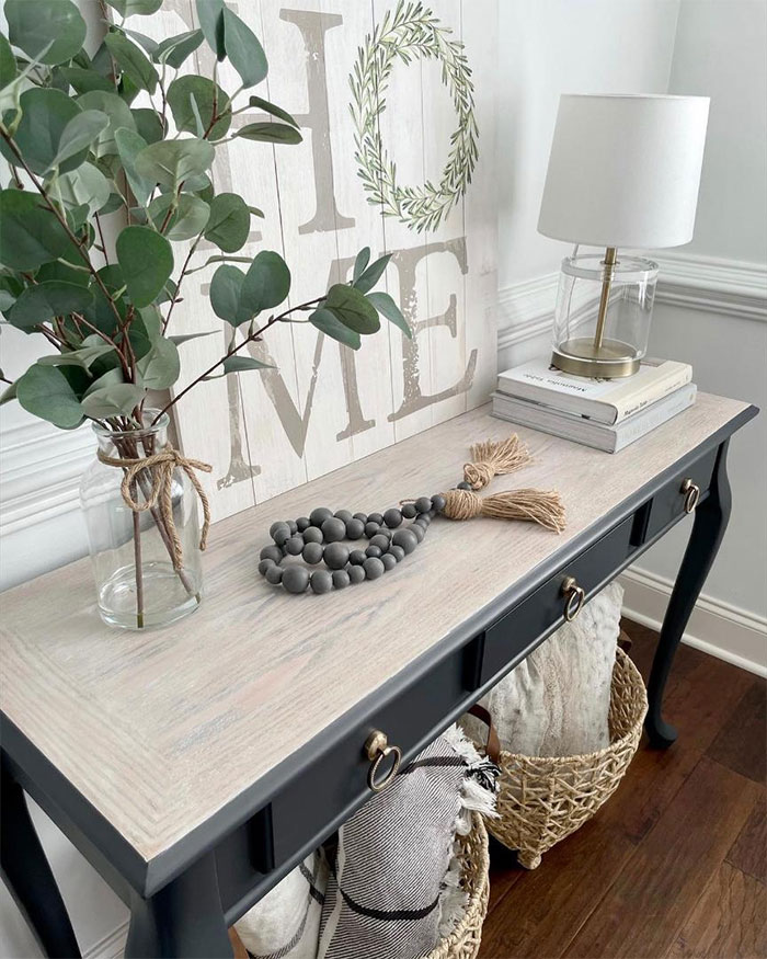 Black table stained with Minwax Tinsmith Gray wood stain in a cozy room setting with decorative items. Black table stained with Minwax Tinsmith Gray wood stain in a cozy room setting with decorative items.