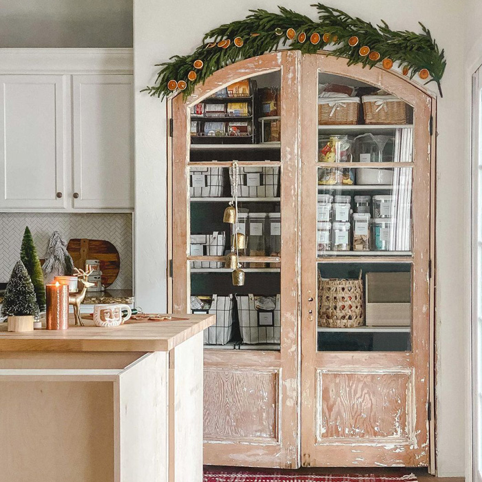 Wooden arched pantry door with orange ornaments on the top of it 