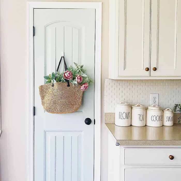 A bag with flowers hanging on baby blue pantry door