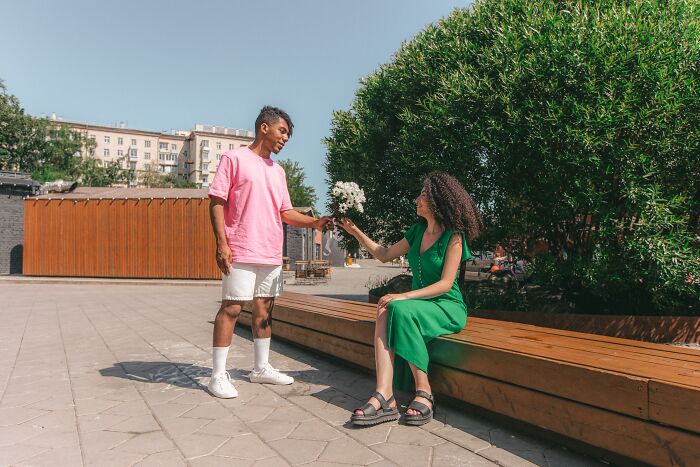 A Couple Looking at Each Other and giving flowers