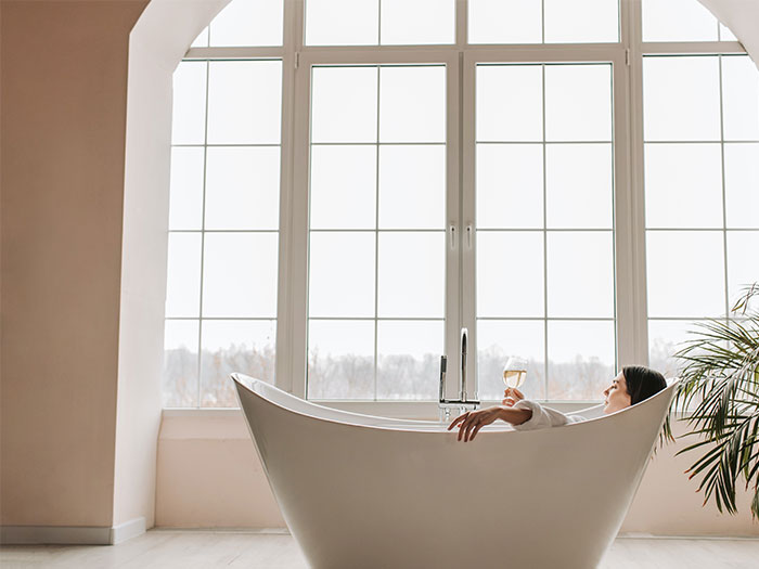 Woman lying on white bathtub