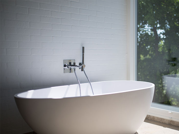 White ceramic bathtub beside clear glass wall White ceramic bathtub beside clear glass wall