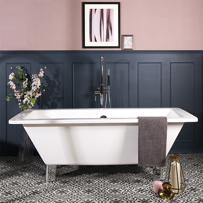 Bathtub in a bathroom with dark blue and pastel pink walls and patterned ceramic tile flooring