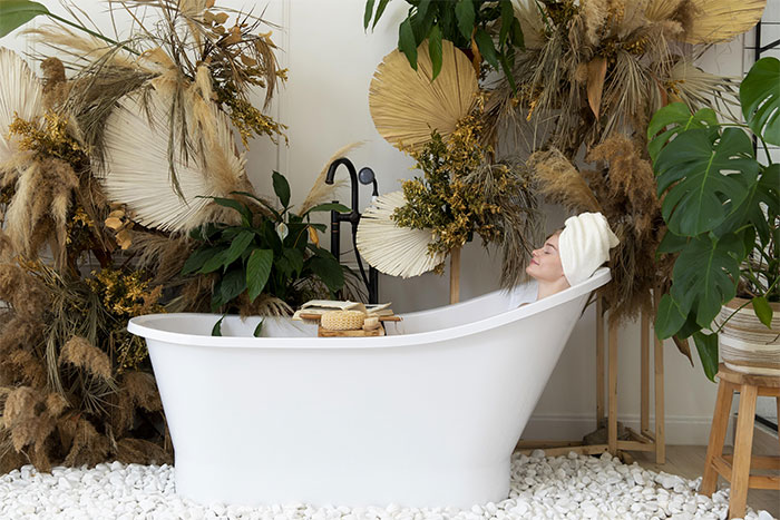 Woman in soak tub near nature leaves and flowers