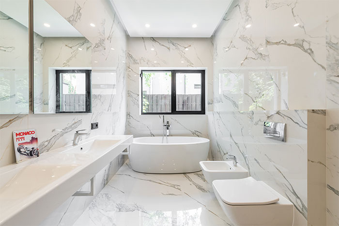 Marble white bathroom with white oval tub