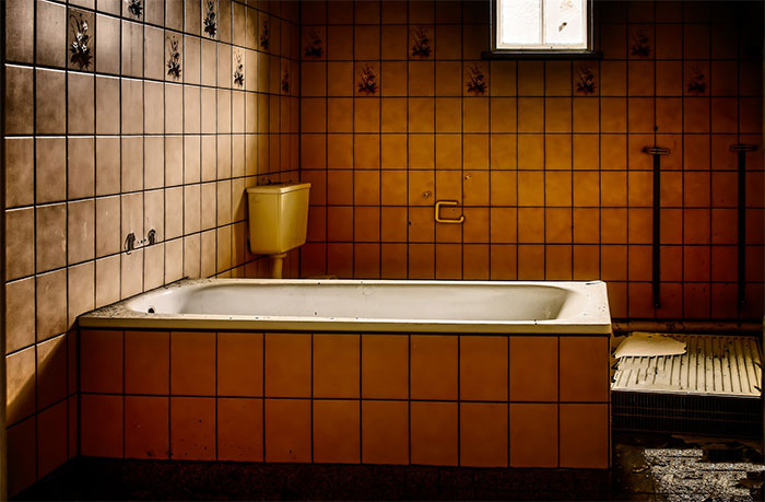 Old dirty bathroom with yellow tiles
