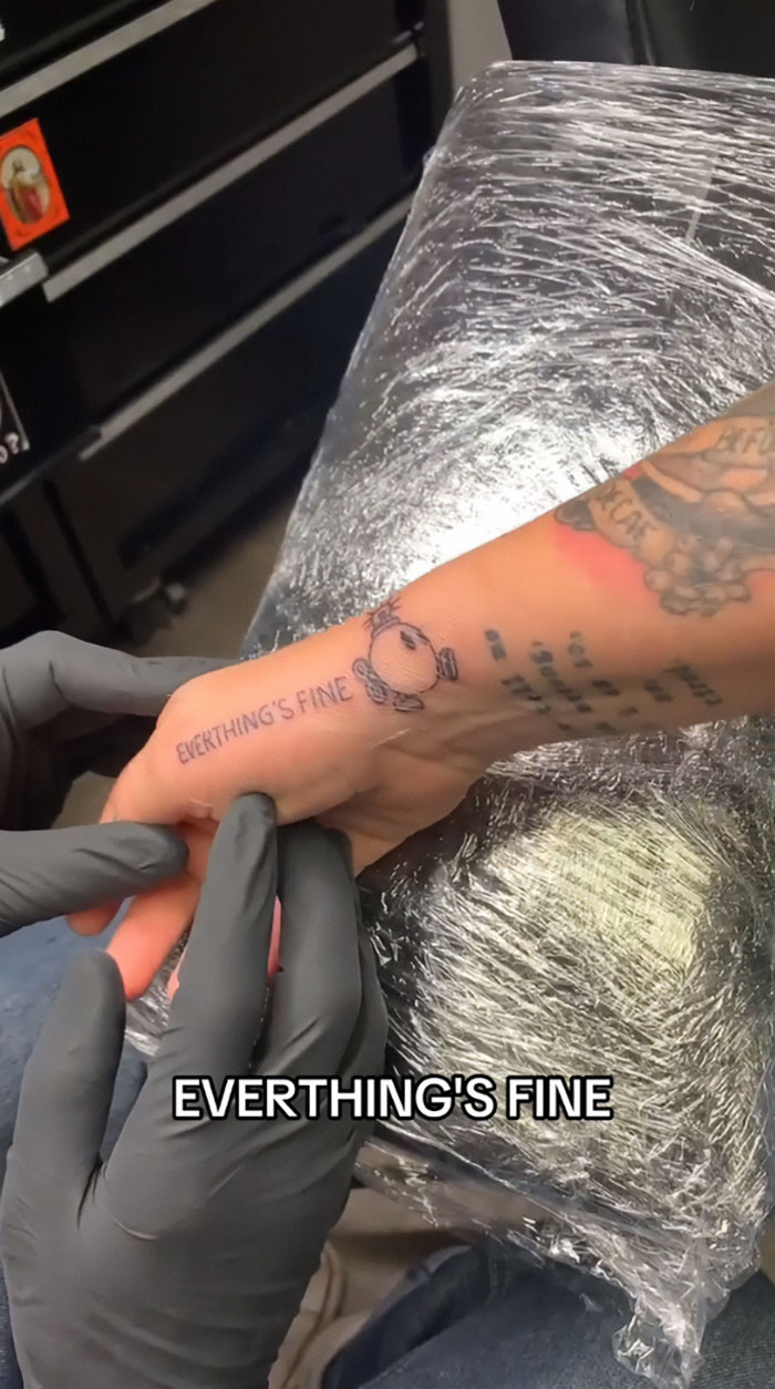 Tattoo mistake on arm with text "EVERTHING'S FINE" causes viral moment on TikTok, sparking artist's crisis. Tattoo mistake on arm with text "EVERTHING'S FINE" causes viral moment on TikTok, sparking artist's crisis.