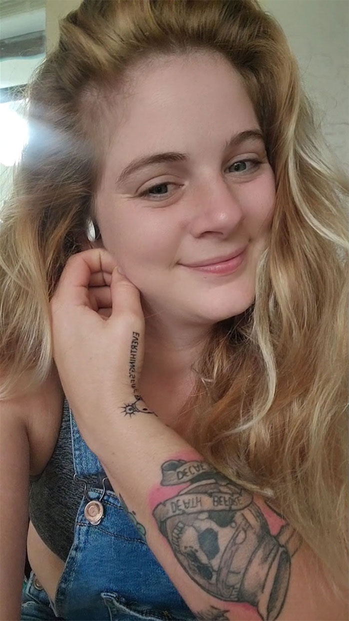 Smiling woman showing tattoo blunder on arm, linked to viral TikTok and artist’s existential crisis. Smiling woman showing tattoo blunder on arm, linked to viral TikTok and artist’s existential crisis.