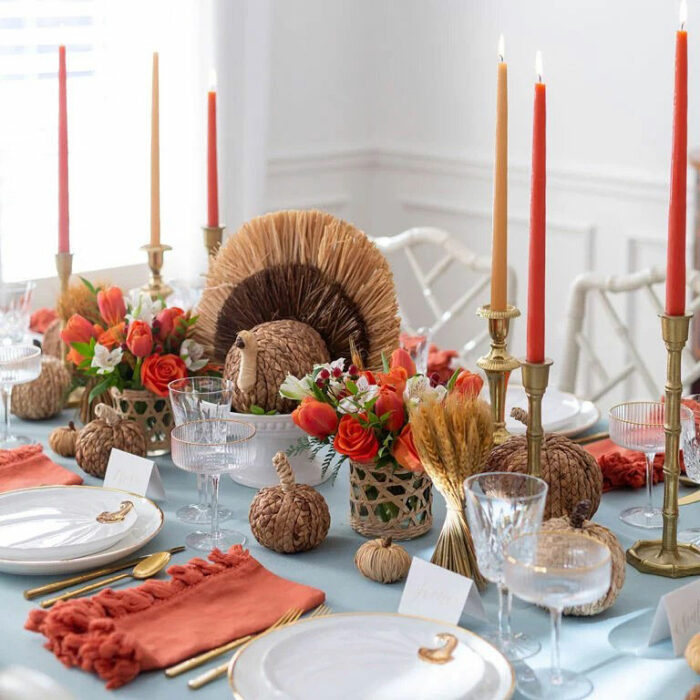 Turkey made from straws near red candles in the center of the table 